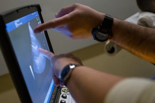 two people pointing at a computer screen
